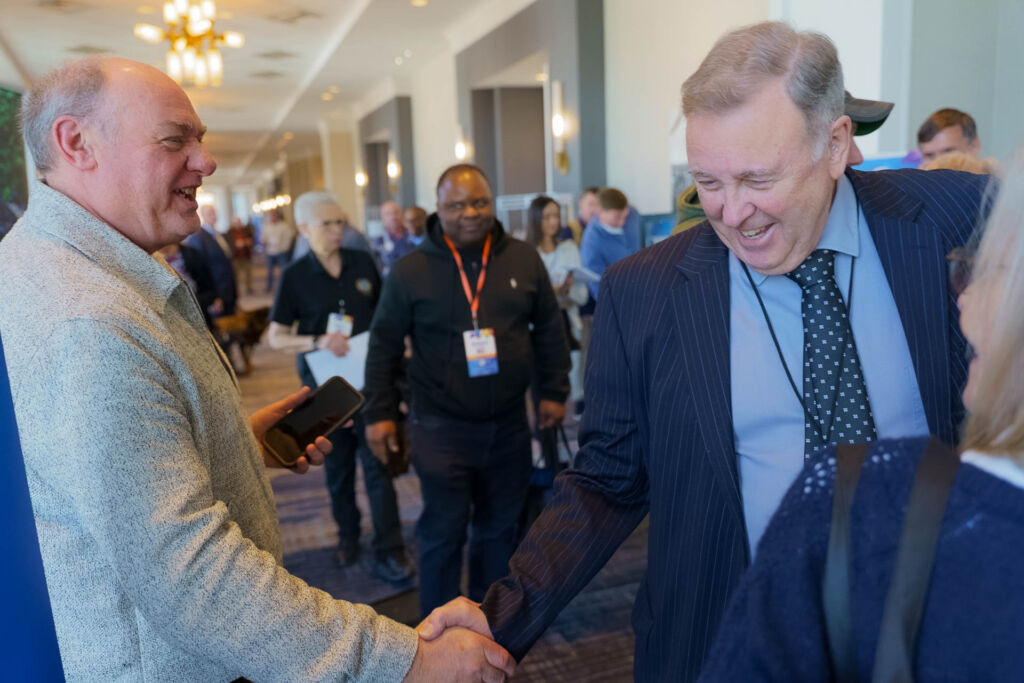 Two people shaking hands at a conference.